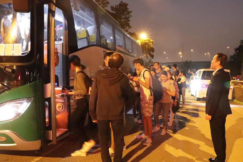 香港中文大學連日發生嚴重警民衝突，香港台北經濟文化辦事處13日晚應要求協助該校台生返台。圖為台生集體步出校園外搭乘專車前往機場。(圖：中央社)