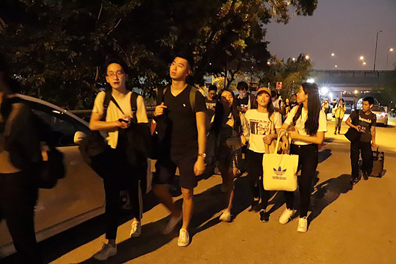 香港中文大學連日發生嚴重警民衝突，香港台北經濟文化辦事處13日晚應要求協助該校台生返台。圖為台生集體步出校園，前往搭乘專車。(圖：中央社)