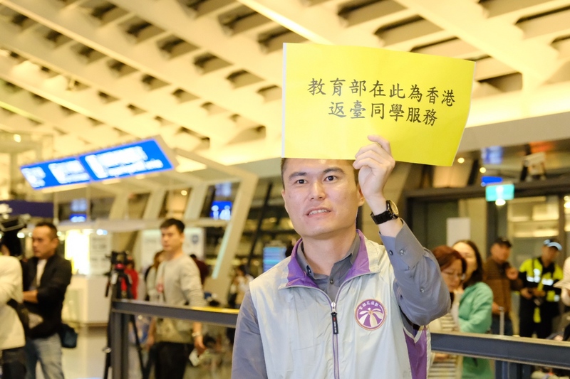 在香港的台北經濟文化辦事處協助下，香港中文大學71名台灣學生在14日凌晨抵台。教育部人員在接機大廳高舉海報，同時表示，若學生14日沒有交通工具可以返家，教育部也提供免費住宿。(圖：中央社)