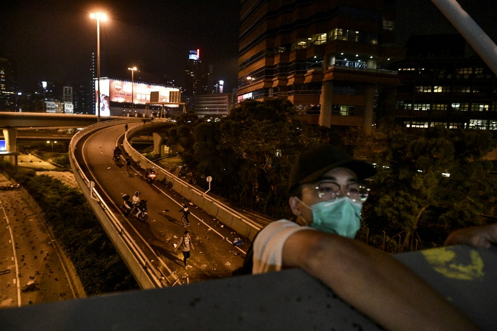 港理大示威民眾以垂繩脫困，再由摩托車載走。(AFP)
