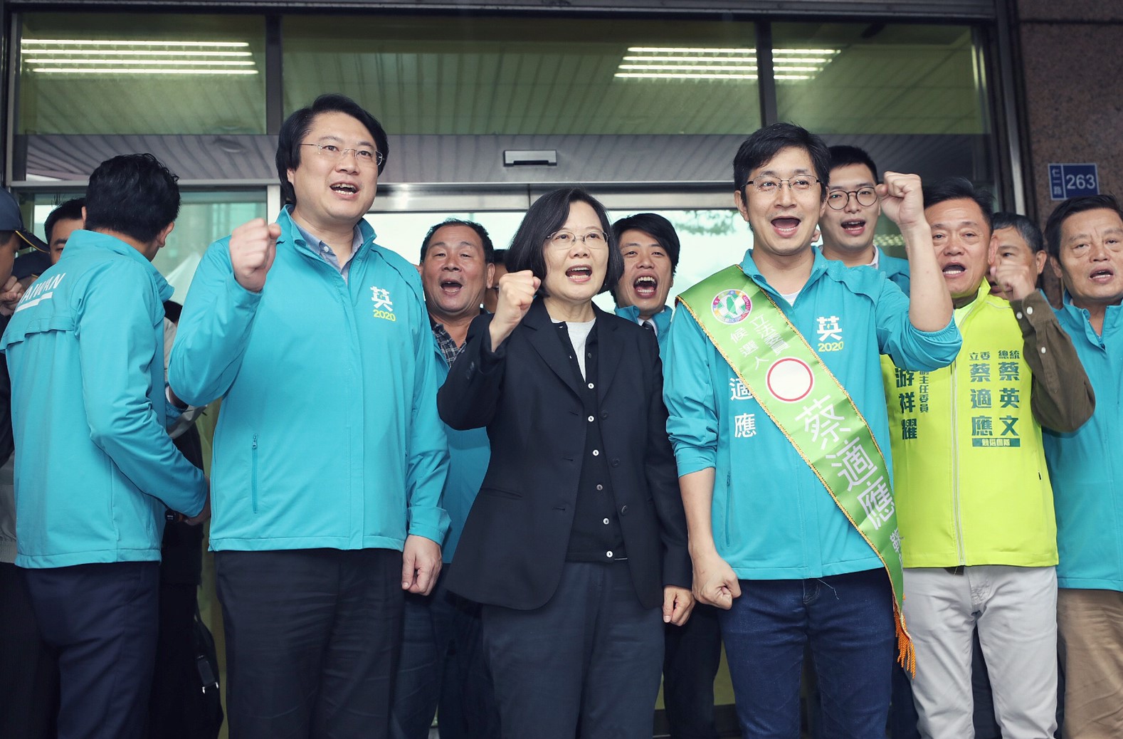 蔡英文總統(前中)21日陪同立委參選人蔡適應(前右)登記後受訪，表示總統最重要的工作是兌現對選民的承諾、誠信及堅守崗位。(蔡總統競選辦公室提供)