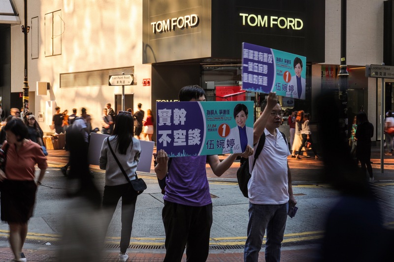 香港24日區議會選舉如期舉行，各個投票點湧入大量人潮。區議員候選人支持者在銅鑼灣街頭拜票。(中央社)