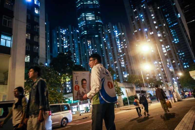 香港近日抗爭情勢逐漸趨緩，24日區議會選舉如期舉行，太古一處投票站晚間人潮不如中午與下午，但仍有區議員候選人支持者在街頭拜票。(中央社)