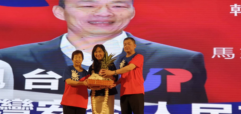 中國國民黨總統參選人韓國瑜的妻子李佳芬（中）26日出席馬來西亞後援會成立活動，獲馬來西亞韓國瑜後援會會長、世界台灣商會聯合總會名譽監事長丁重誠（右）贈送凍蒜、包子與鳳梨，象徵能順利當選。(圖:中央社)