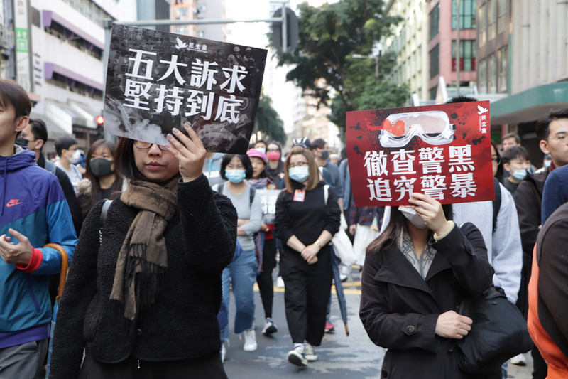 香港民間人權陣線8日舉行「國際人權日」遊行，下午3時正式起步。圖為民眾高舉「五大訴求，缺一不可」和「徹查警黑，追究警暴」的標語行進。(圖：中央社)