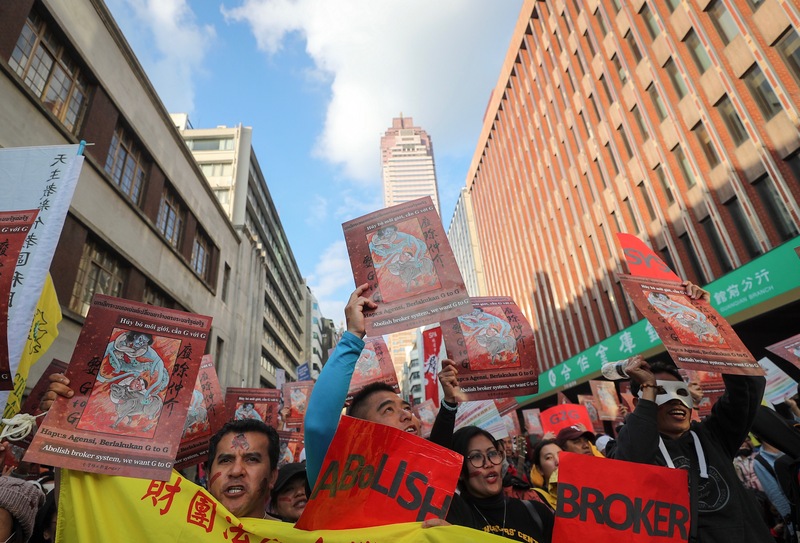 移工大遊行8日在台北登場，下午遊行至勞動部，隊伍沿途高舉標語，訴求廢除私人仲介制度、要求政府對政府直接聘僱，讓移工免於被仲介剝削。（中央社）