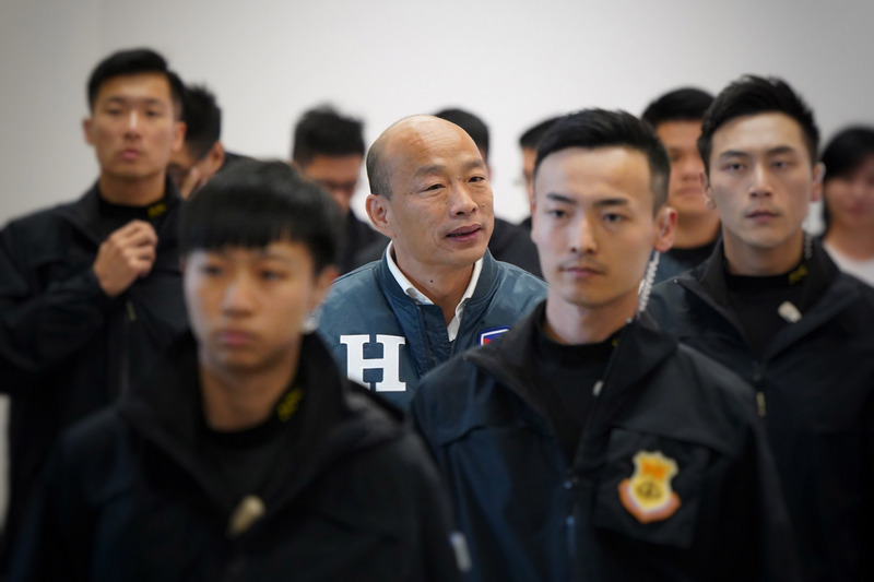 國民黨總統參選人韓國瑜（中）9日在維安人員層層保護下，前往台北市一處電視台錄製談話性節目。(圖：中央社)