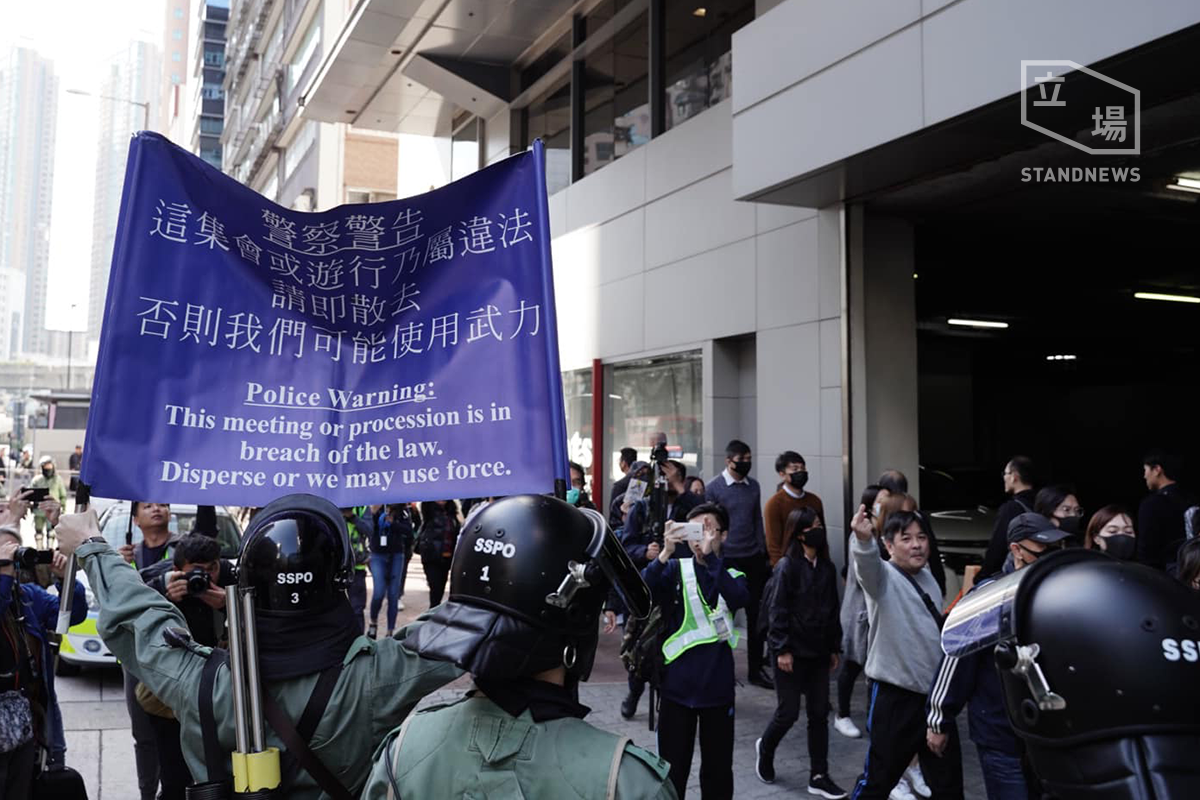 香港網民今天在多區發起「和你lunch」行動，防暴警員舉藍旗，但是群眾沒有理會。(圖: 立場新聞)