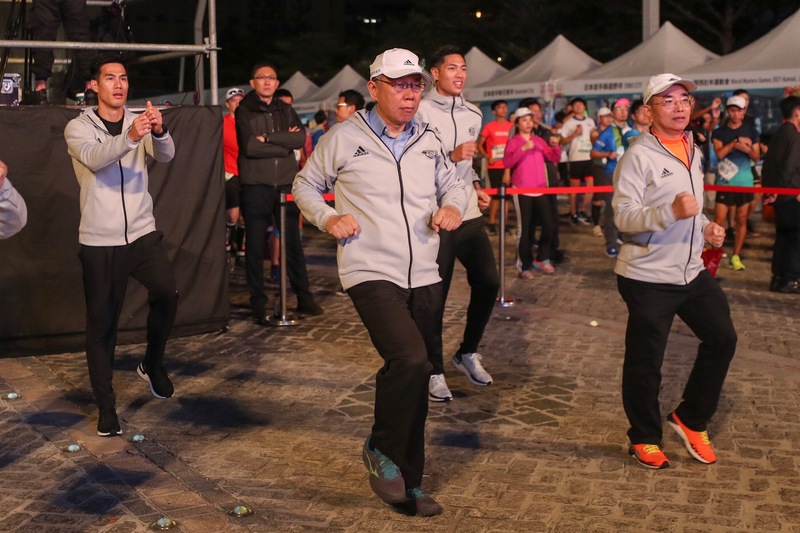 台北馬拉松15日在台北市政府前廣場開跑，台北市長柯文哲（前中）、田徑好手楊俊瀚（後排左）、陳傑（後排右）出席與會。（圖：中央社）