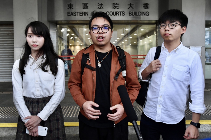 香港眾志主席林朗彥（中）、秘書長黃之鋒（右）及成員周庭（左）19日赴東區裁判法院應訊。黃之鋒、林朗彥在庭中申請離港欲來台觀選，遭到裁判官拒絕。（中通社提供）(圖：中央社)