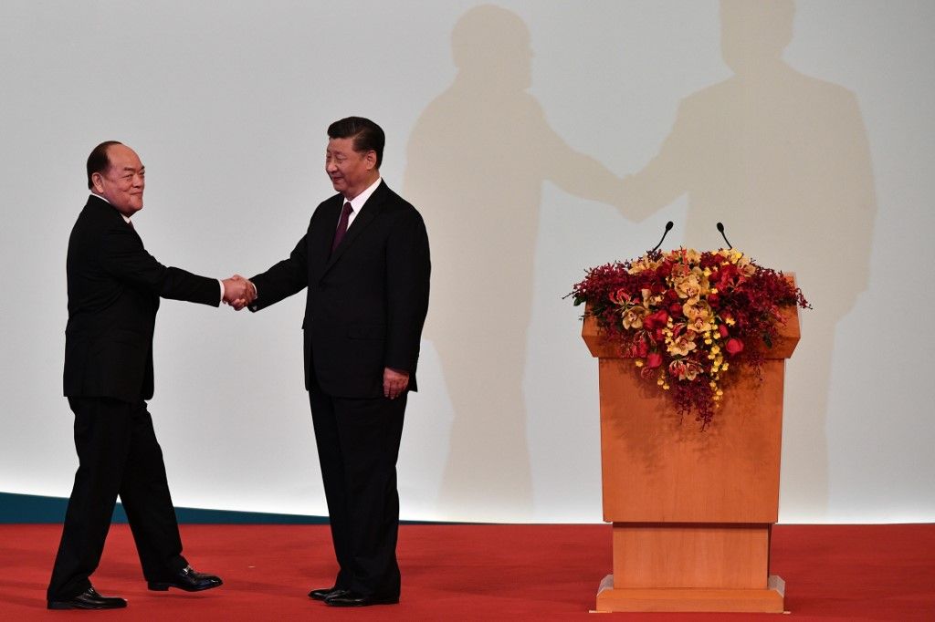 澳門新任行政長官賀一誠(左)在宣誓後，與中國國家主席習近平握手。(AFP)