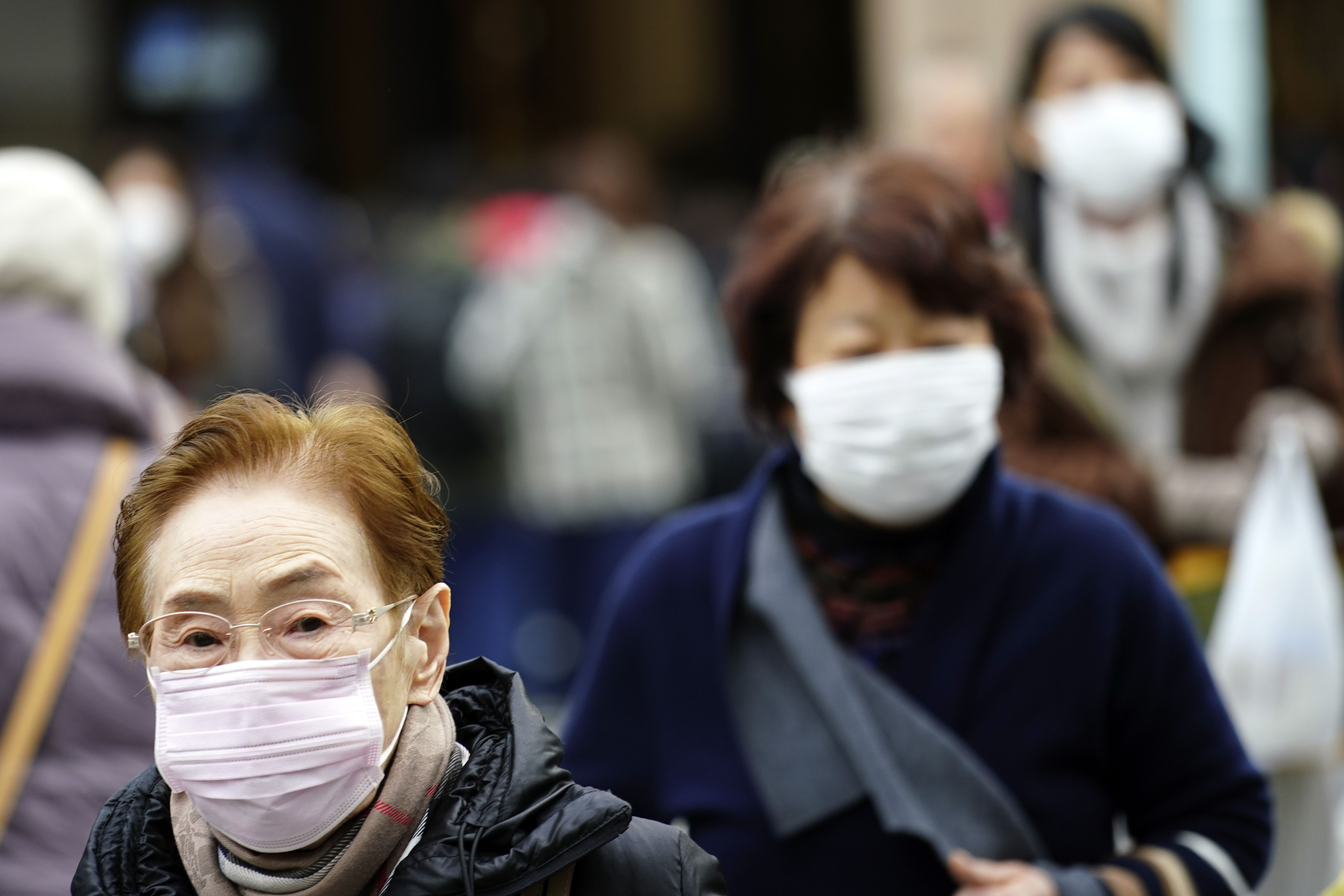 中國武漢肺炎疫情延燒。圖為日本東京街頭民眾戴上口罩防疫。(美聯社/達志影像)