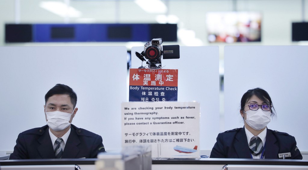 中國「武漢肺炎」疫情持續擴大，圖為日本成田國際機場對來自武漢的旅客進行體溫檢測。(AFP)
