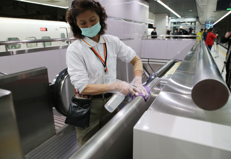 台酒公司：酒精存量足，請民眾安心。圖為台灣高鐵清潔人員30日在電扶梯噴灑酒精消毒。(圖：中央社)