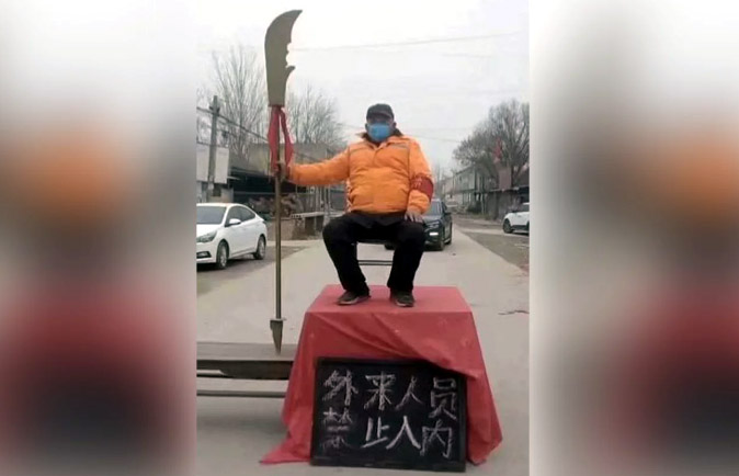 武漢肺炎疫情延燒，中國各地民眾自製簡易路障，有照片顯示，1名男子揮舞武術刀，呼籲「外來人員禁止入內」。（翻攝自網路）