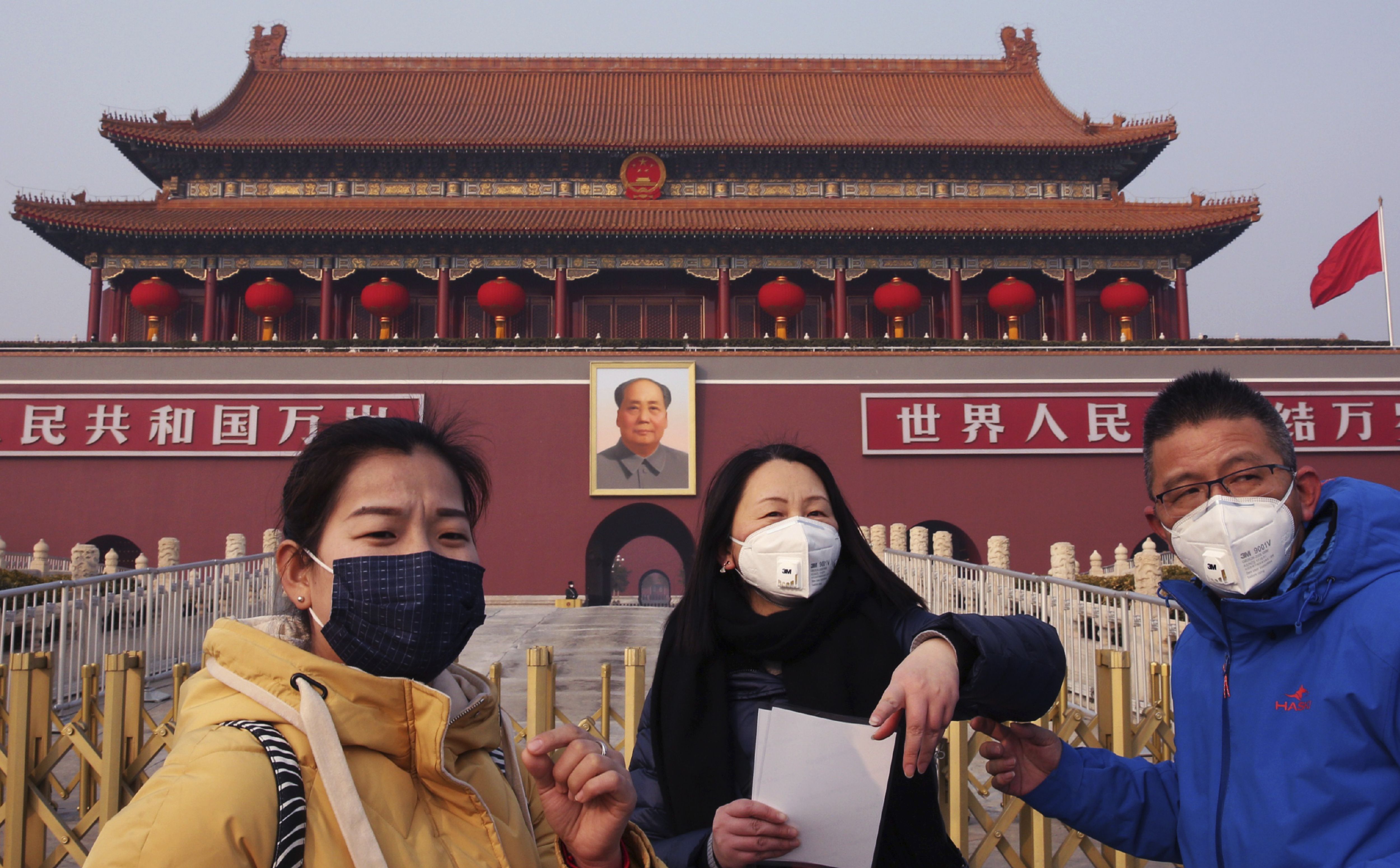 中國武漢肺炎疫情嚴重，使各國紛紛對中國公民或從中國出境人士採取管制措施。圖為遊客戴口罩在天安門廣場拍照。(AP/達志影像)
