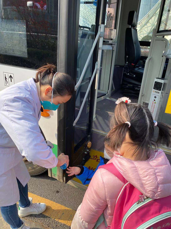 首批滯留武漢的200多名台人預計3日晚間搭機返台，一行人中午集結上車，準備前往機場。圖為2名首批返台的兒童在上車前消毒雙手。（台北家長會長協會提供）