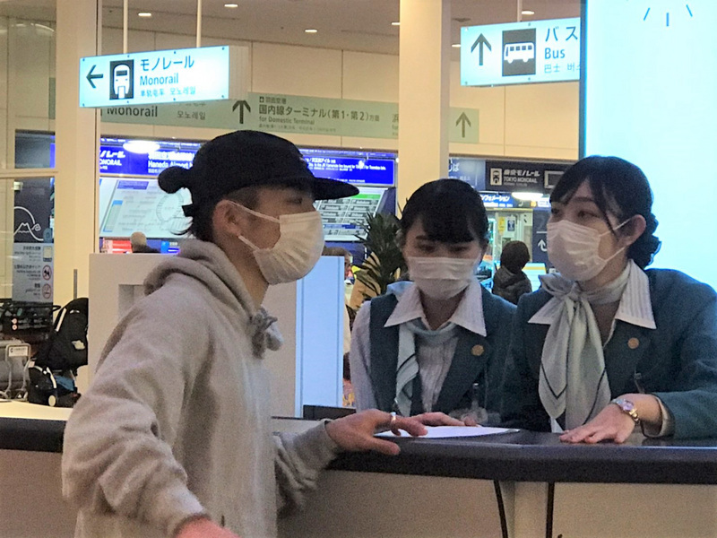 日本爆發武漢肺炎疫情 ，東京羽田國際機場服務檯人員，與搭機旅客很多都戴上口罩。(資料照片/中央社)