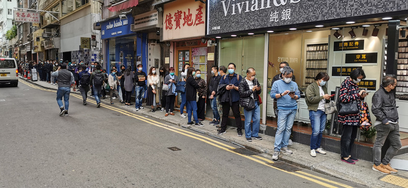 新型冠狀病毒肺炎持續擴散，香港9日出現9名家庭成員同遭感染的疫情。圖為市民7日在灣仔一家藥店外排隊買口罩。(中央社)