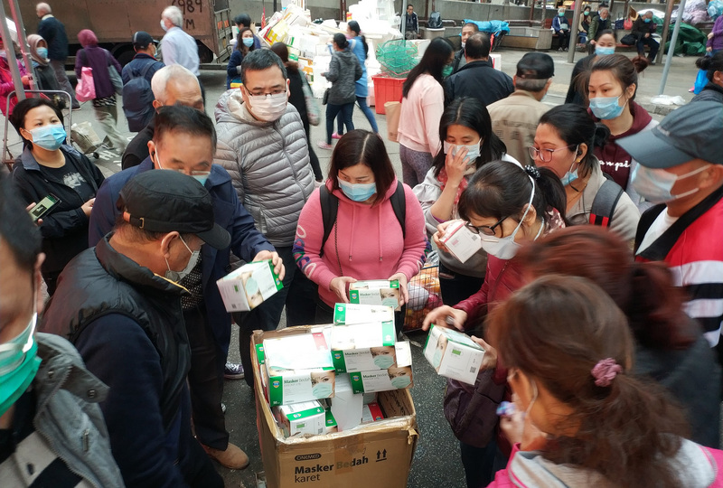香港爆發口罩荒，一名小販在香港街頭賣口罩，吸引市民圍觀。（資料照片/中通社提供）(圖：中央社)