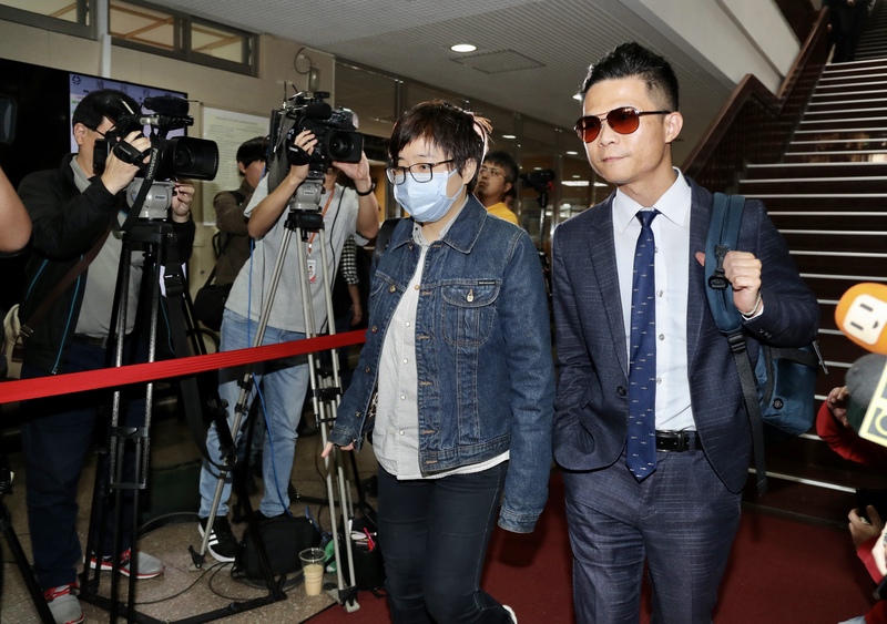 「卡神」楊蕙如（前左）被控利用網路PTT論壇，侮辱大阪辦事處，被台北地檢署依侮辱公署罪起訴。台北地方法院14日首次開庭，楊蕙如在律師陪同下戴著口罩出庭。(圖:中央社)