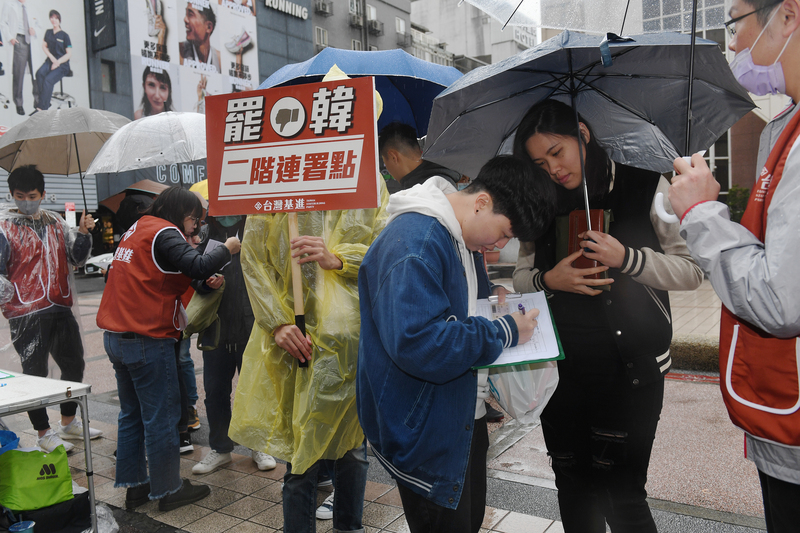 台灣基進黨16日在台北西門町發起第一次雙北罷韓街頭連署，雖然15日已達到30萬份目標，仍有許多北漂高雄青年冒雨在低溫中參與連署活動。(圖：中央社)