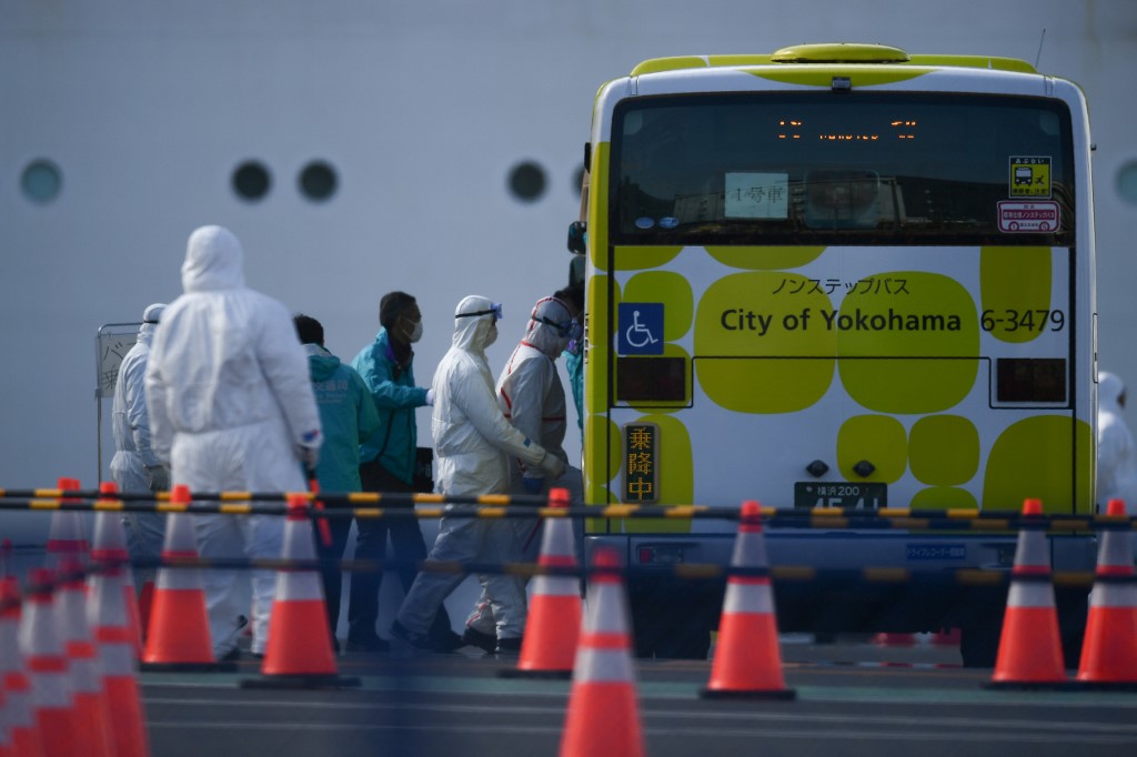 爆發疫情的鑽石公主號郵輪19日解除隔離，日方安排首批500名乘客陸續下船。 (AFP)