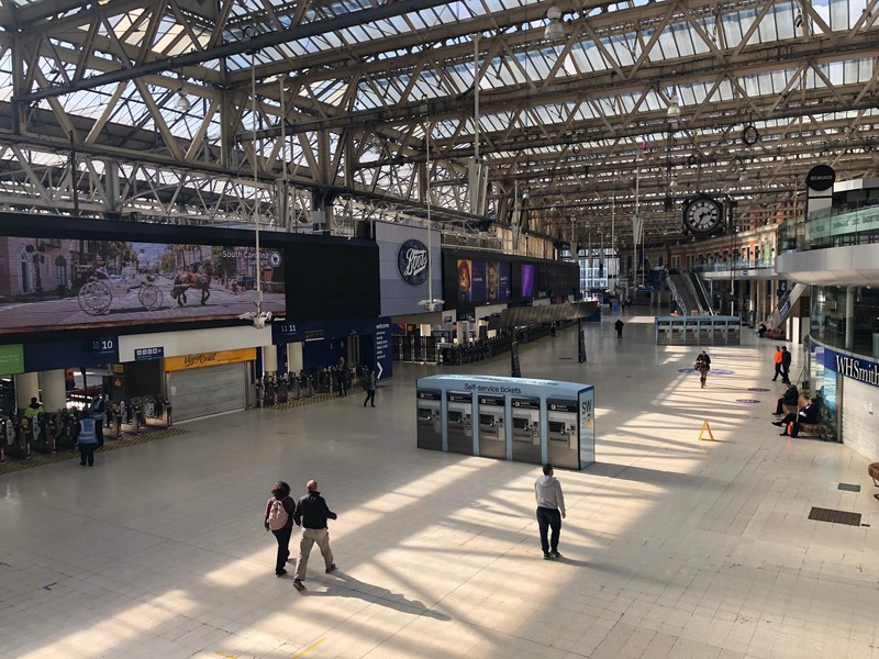 英國實施3週禁足令，以往不分平假日都人潮洶湧的倫敦滑鐵盧車站，25日僅有行色匆匆的數名乘客。(圖:中央社)