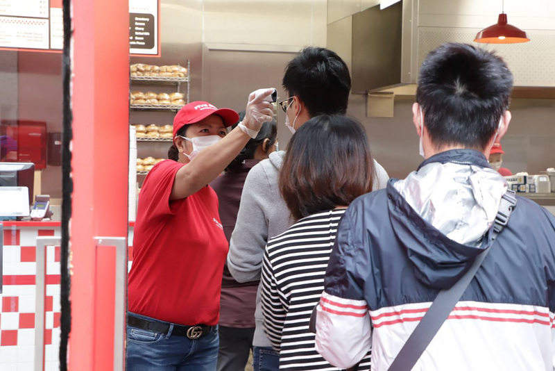 香港新增5例確診武漢肺炎 累計1009例。圖為位在香港灣仔的餐廳依照規定為客人量體溫。(中央社)