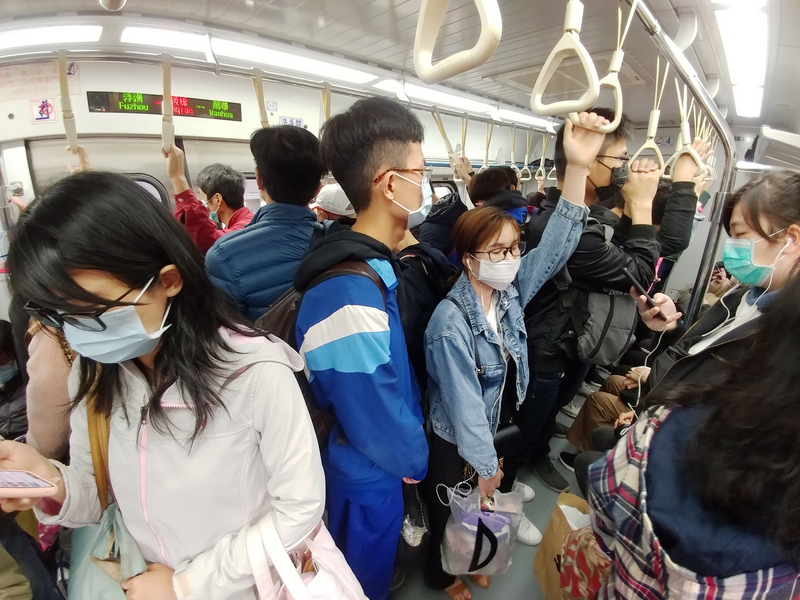 台灣確診數仍攀升，交通部要求民眾搭大眾運輸一律配戴口罩；圖為6日桃園往台北台鐵電聯車上，每一名通勤族都戴口罩防疫。(圖：中央社)