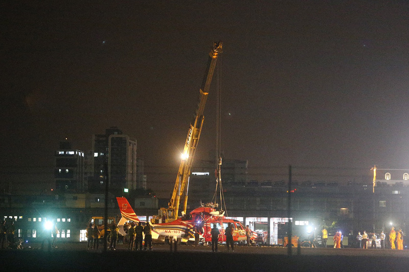 高雄小港機場7日下午發生空勤直升機落地翻覆事件，晚間出動吊車將側翻的機身吊起回正，並在拖離跑道後重新恢復班機起降。(圖：中央社)