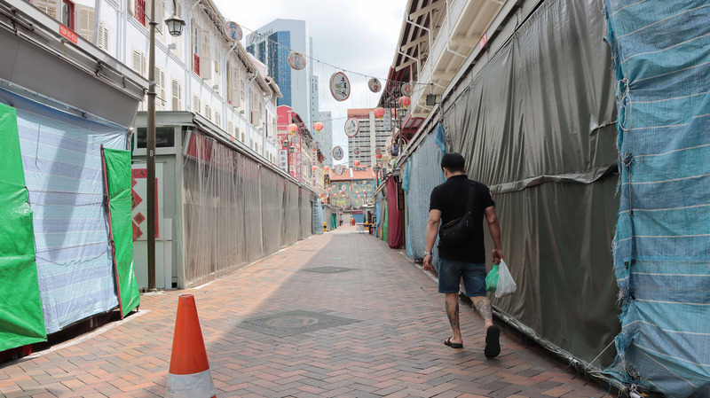 新加坡政府執行嚴格的社交安全距離，凡非必要服務場所都關閉1個月，原本人潮聚集的牛車水顯得泠清，商家多半大門深鎖，偶有路人經過。 (圖:中央社)