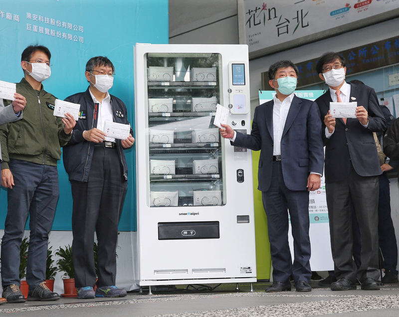 台北市政府與衛生福利部及中央健保署合作，共同推動「實名制口罩自動販賣系統」試辦計畫，衛福部長、中央流行疫情指揮中心指揮官陳時中（右2）、健保署長李伯璋（右1）與台北市長柯文哲（左2）11日出席系統上線記者會，親自試用口罩販賣機。(圖：中央社)