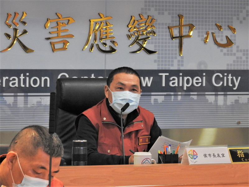 新北市長侯友宜（後）14日主持「因應嚴重特殊傳染性肺炎疫情第40次應變會議」時表示，預定20日進行兵棋推演，將以疫情突然瞬間上升的最壞打算，以全民防衛總動員機制模擬擴大管制作為。(圖：中央社)