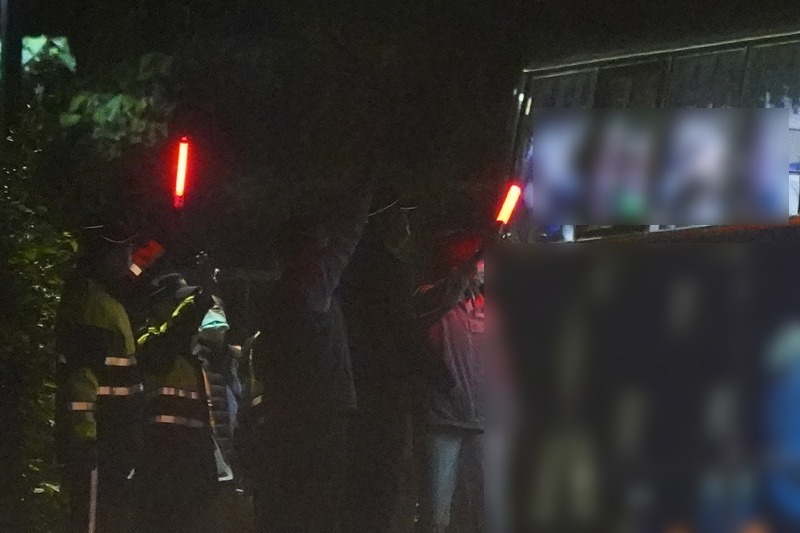 日前搭乘第2班類包機，從上海返台的滯留湖北台灣人，於14日零時起解除隔離，部分民眾搭乘遊覽車離開北部集中檢疫所，醫護人員與警察揮別檢疫者。(圖：中央社)