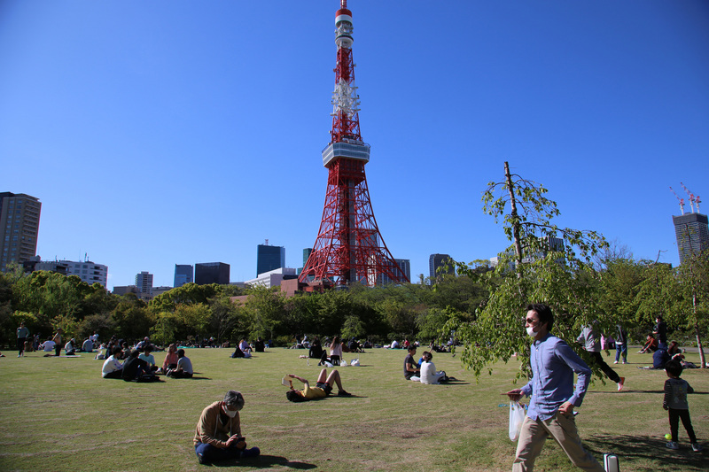 武漢肺炎疫情嚴峻，日本政府呼籲民眾少出門，但19日週日天氣晴朗，東京鐵塔附近公園可看到很多遊客。(圖:中央社)