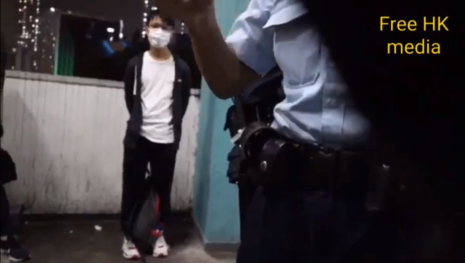 Free HK media 的記者在採訪時，與經過的路人被港警以「限聚令」為由攔查。(Free HK media影片截圖)