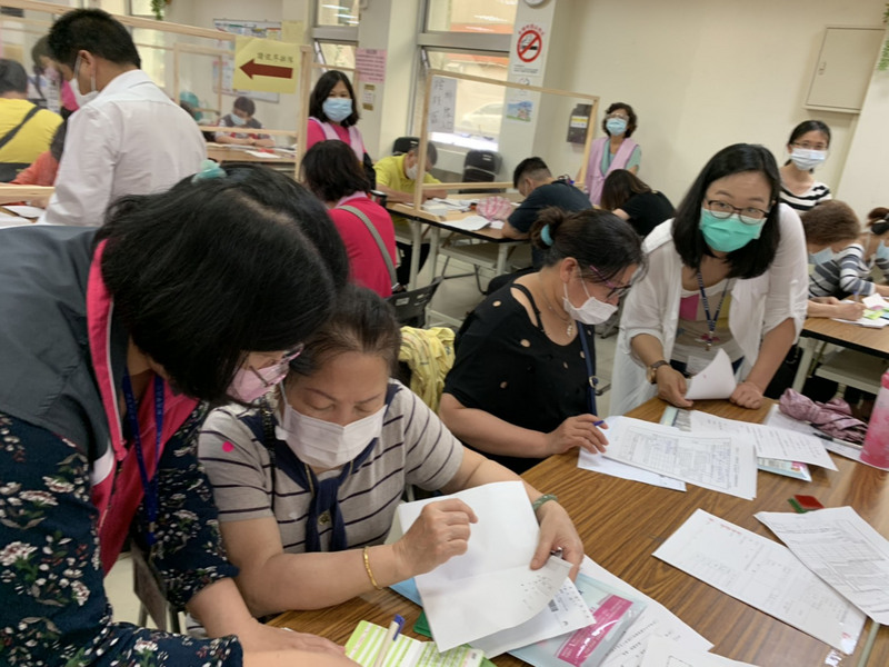 考量疫情衝擊，政府推出萬元紓困加碼方案，但因為程序不夠清楚，造成民眾抱怨聲四起。圖為三重區公所7日約動員50名同仁進行作業。(圖：中央社)