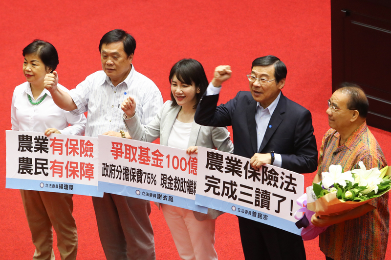 為保障農民收入，填補天然災害損失，立法院12日三讀通過農業保險法，國民黨立委曾銘宗（右2）、謝衣鳳（中）、楊瓊瓔（左）等人拿看板、齊呼口號慶祝。(圖：中央社)
