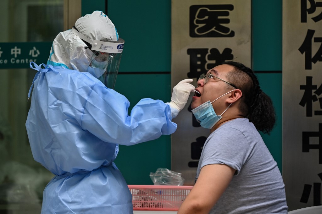 圖為湖北武漢市醫護人員為民眾篩檢。 (AFP)