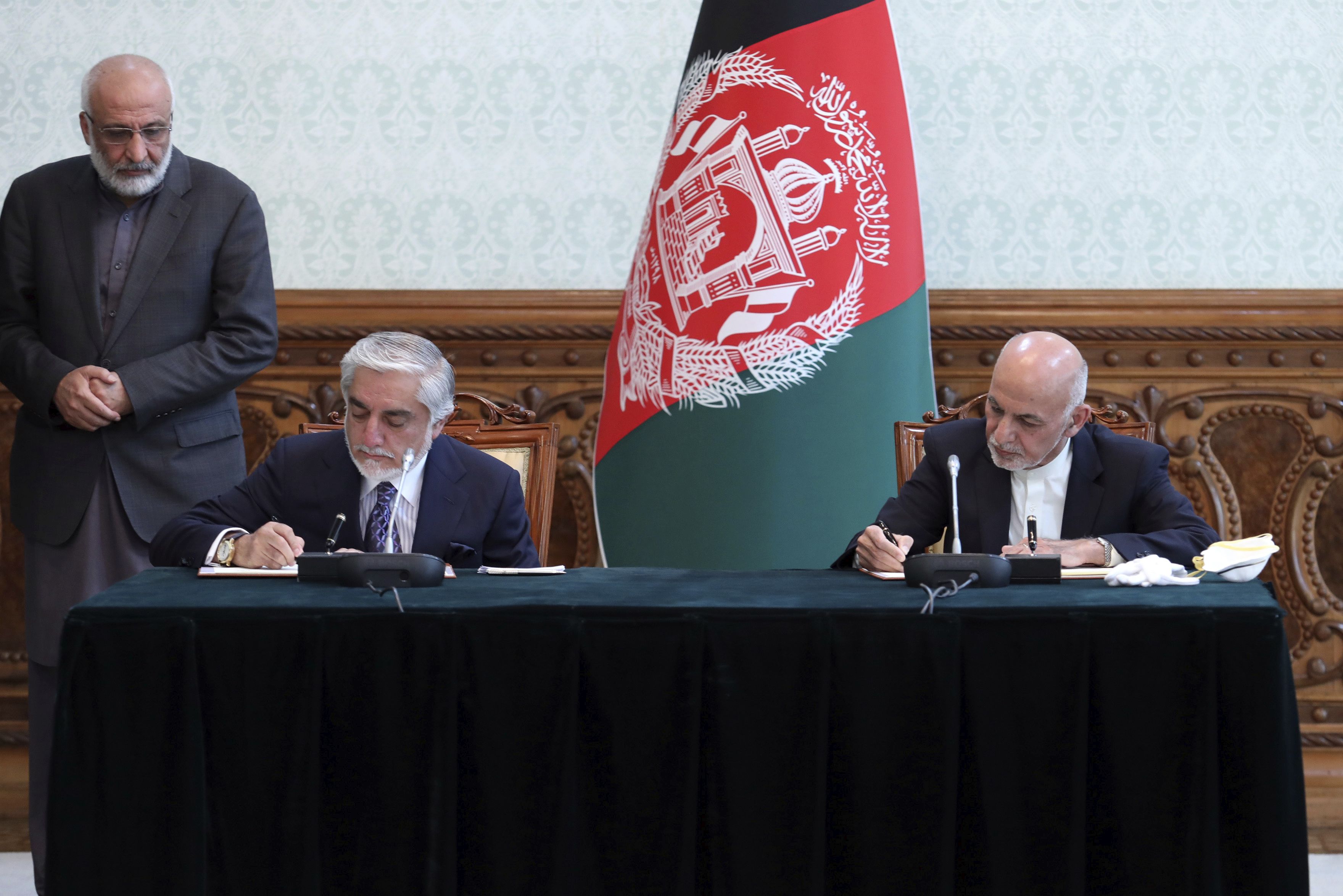 阿富汗總統甘尼(Ashraf Ghani)(右)及政治對手阿布杜拉(Abdullah Abdullah)17日簽署權力共享協議。(美聯社/達志影像)