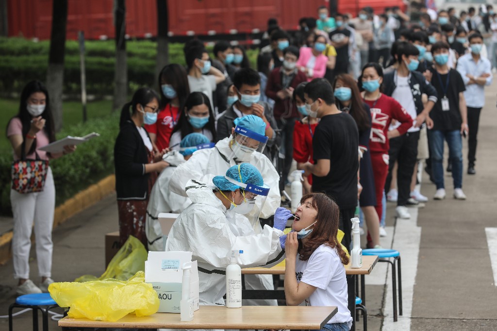 圖為武漢市進行大規模普篩，受檢人潮大排長龍。(AFP)