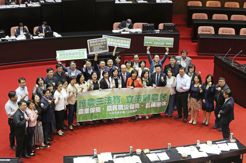立法院會22日三讀通過農民退休儲金條例，關鍵條文是農民與政府的提繳比率，最後表決通過民進黨團版修正動議。圖為民進黨立法院黨團在議場喊口號，宣示護農民決心。(圖：中央社)