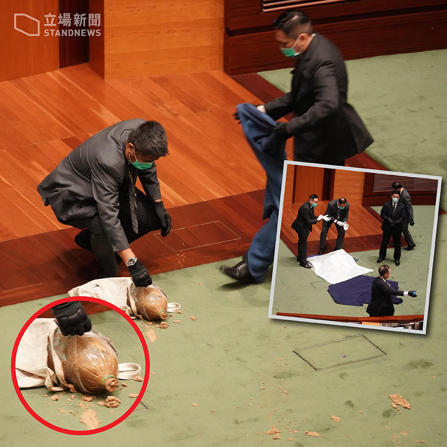 香港立法會28日繼續審議《國歌法》，民主黨議員許智峯將一袋物品放到主席台前，立法會會議暫停，保安立即處理。(立場新聞提供)
