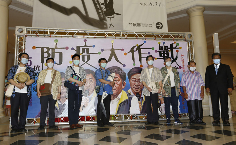 中央流行疫情指揮中心指揮官陳時中30日率同為「防疫五月天」的指揮中心團隊成員周志浩造訪台南奇美博物館，眾人換上休閒襯衫，在國寶級電影看板手繪大師顏振發親筆繪製的巨幅繪像前留影。(圖：中央社)