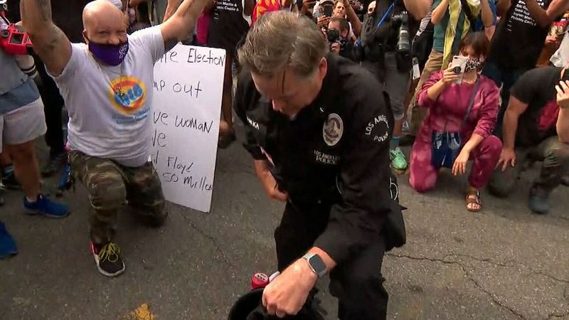 洛杉磯警官帕爾卡(Cory Palka)1日站在抗議群眾當中，脫下頭盔、拿起擴音器，請求群眾保持和平並承諾願以單膝下跪回應。(臉書)