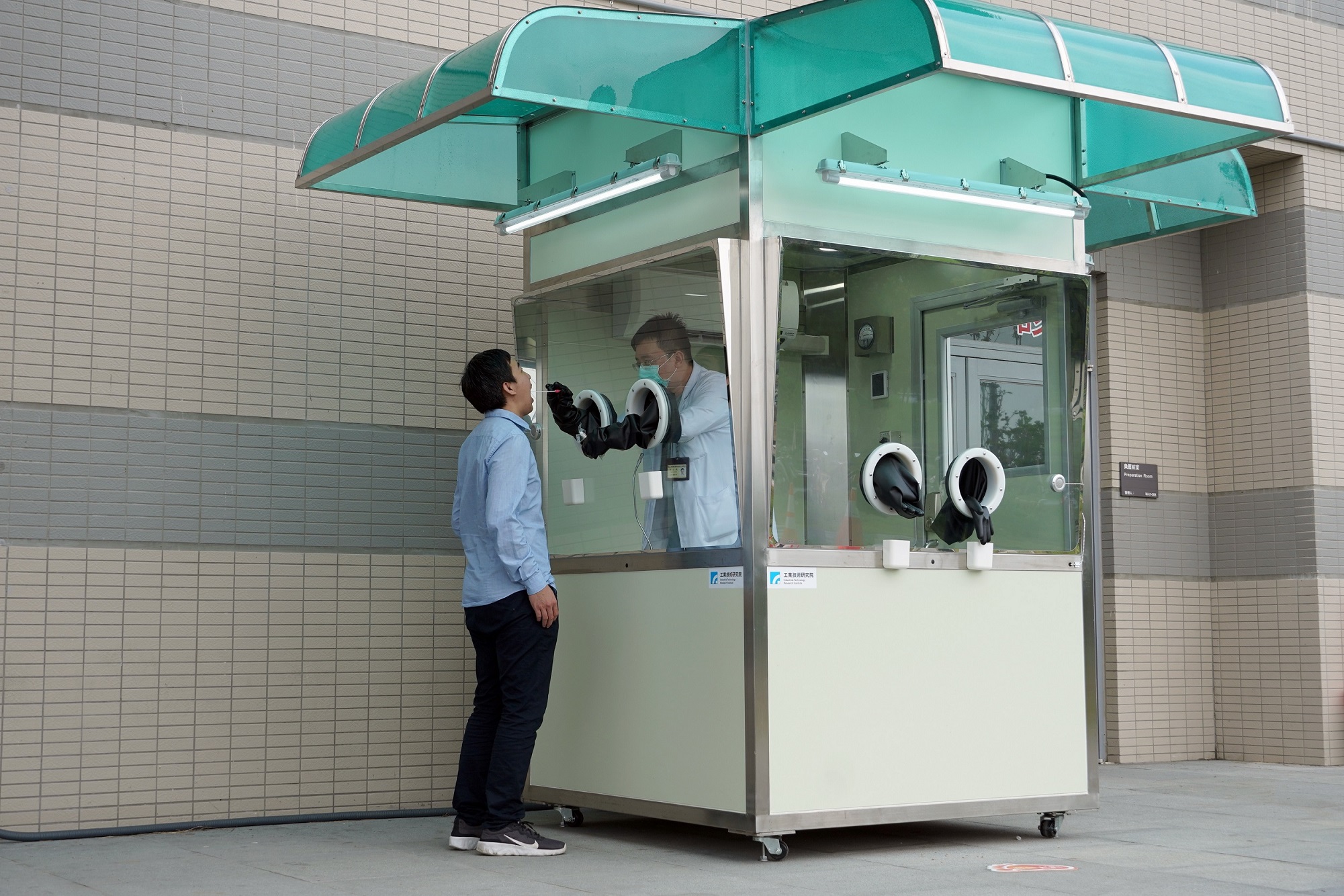 臺大醫院新竹生醫園區分院急診室醫師使用工研院正壓式檢疫亭，為病患進行採檢。（資料照／工研院提供）