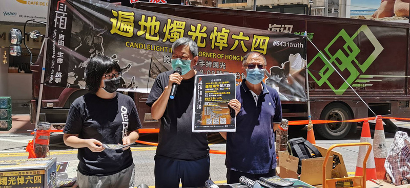 香港支聯會主席李卓人(中)表示收到警方通知，將控告他煽動未經批准的集會。圖為李卓人及成員中午在銅鑼灣擺攤，呼籲市民簽名悼念六四死者，並宣傳晚間的燭光紀念活動。(圖：中央社)