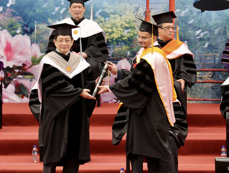 台灣大學6日舉行畢業典禮，校長管中閔（前左）頒發畢業證書給畢業生，向畢業學生表達誠摯的祝福。(圖：中央社)