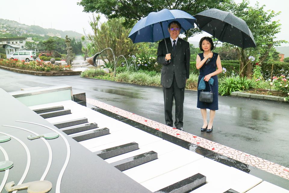 日本駐台代表泉裕泰夫婦在雨中造訪鄧麗君墓園。(日本台灣交流協會臉書)